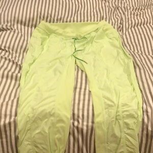 Lululemon women’s studio cropped pants in a bright light green.